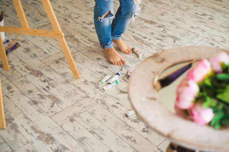 Young inspired girl choosing paint tube in light studio.の写真素材