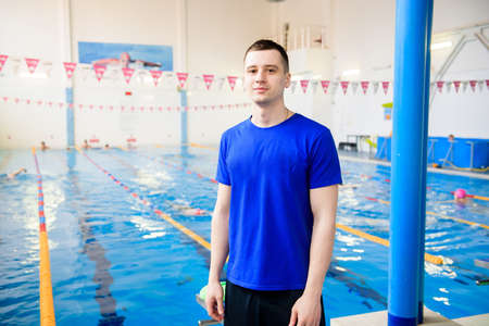 A young swimming coach near the sports pool.