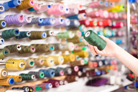 Colorful cones and spools of thread at an atelier.Tailoring, garment industry, designer workshop concept.の写真素材