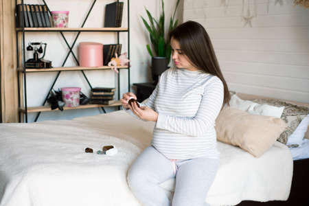 Pregnant woman holding medicine. Girl holding pills in her hands.の写真素材