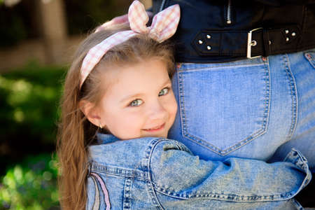 Beautiful young mother and her adorable little daughter, cute little curly girl playing and walking...