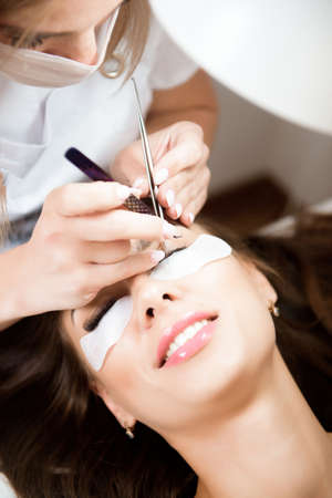 Beautician working on upgrading silk eyelashes in a beauty studio.の写真素材