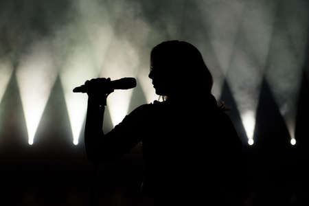 Singer in silhouette. Close up image of live singer on stageの写真素材