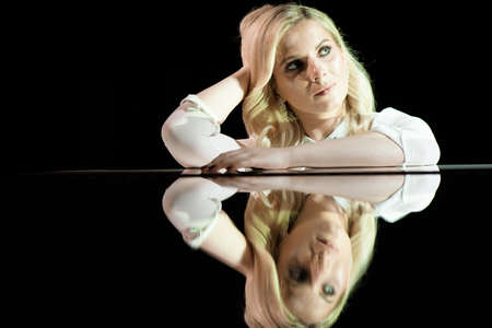 Portrait of a beautiful actress near a white piano.