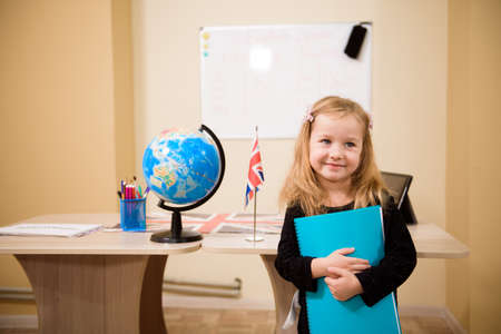 Portrait of diligent girl looking at camera in the classroom.の写真素材