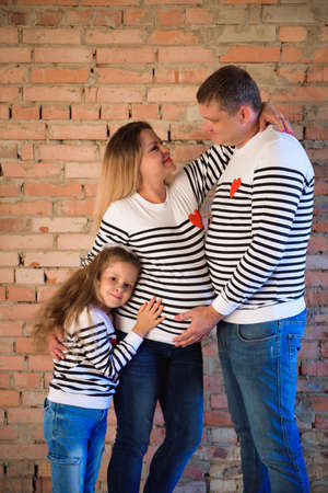 Young pregnant woman with her family, studio shootの写真素材
