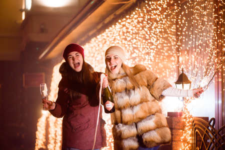 Cheerful laughing girls celebrating party with champagne.