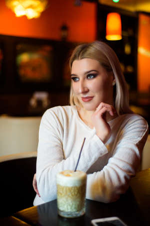 Winter girl is drinking coffee. She enjoys her cappuccino or flat white.の写真素材