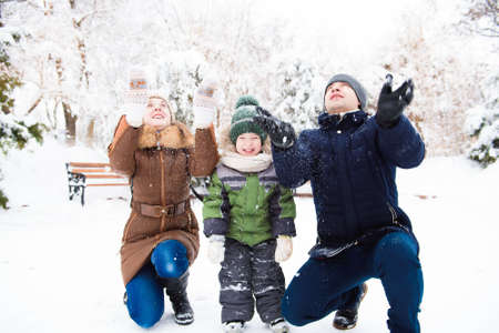 happy family having fun and playing with snow in forestの写真素材