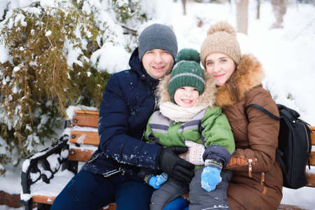 Father holding the sun while playing in the park. Mom kissing small sun.の写真素材