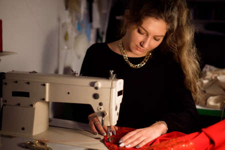 Tailor sewing on sewing machine. Strain the tissue.