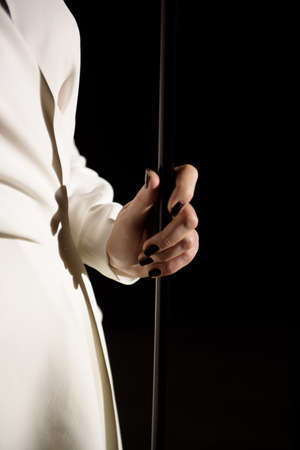 Back view of a singer with microphone singing a song on stage in white lights.の写真素材