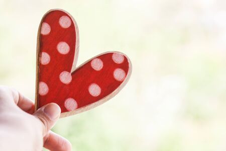 hand holding red polka dot heart