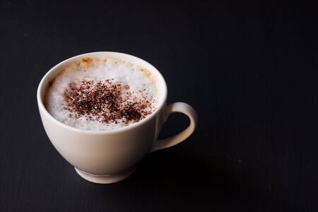 a cup of latte coffee on a black backgroundの写真素材