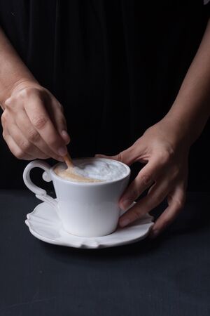 hand holding a cup of coffee, latte coffeeの写真素材