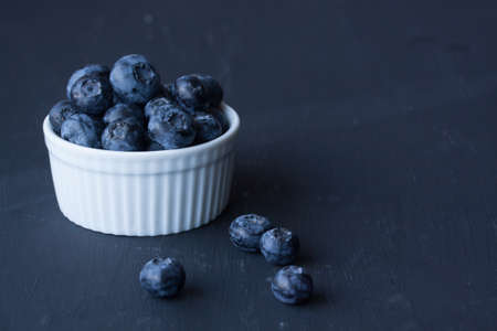 Blueberries in a bowl on a black backgroundの写真素材