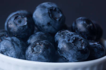 Blueberries in a bowl on a black backgroundの写真素材