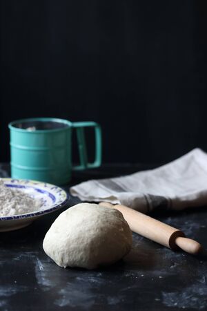 Dough, making dough with flour on a black background, bread and pizza dough
