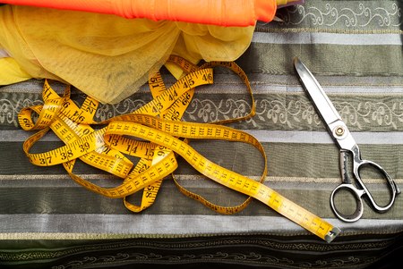 Sewing textile or cloth. Work table of a tailor. Textile tools. Scissors, measuring tapes.  Top view. Copy space.の写真素材