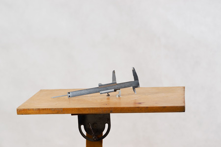 Different construction tools on a wooden background - screwdriver, caliper. Top view.の写真素材