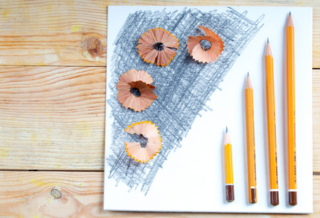 Pencil sharpener shavings on the white paper. Back to school