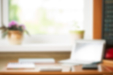 Abstract office desk table with computer, supplies, flower blur background. Copy space for text.の写真素材