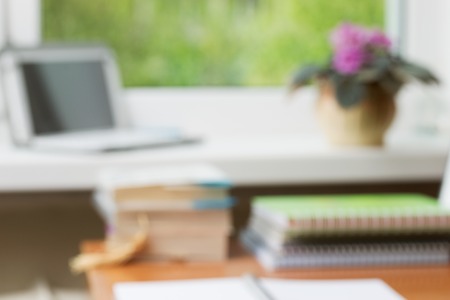 Abstract office desk table with computer, supplies, flower blur background. Copy space for text.