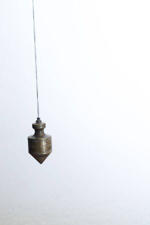 Metal plummet hanged on a rope.の写真素材