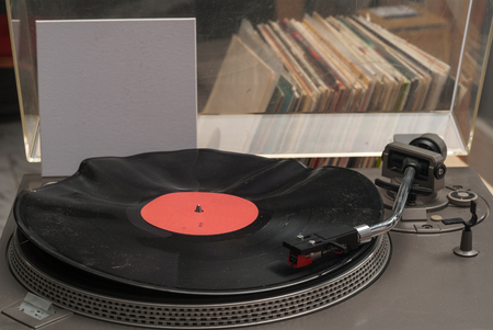 Detail shot of a record player.Vinyl record with copy space in front of a collection of albums dummy titles isolated on white background. vintage process.の写真素材