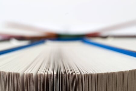 Open book, stack of hardback books on wooden table. Back to school. Copy space.