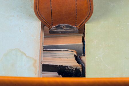 Stack of hardback books in an old suitcase with a retro effect. Back to school. Copy space. Top view.の写真素材