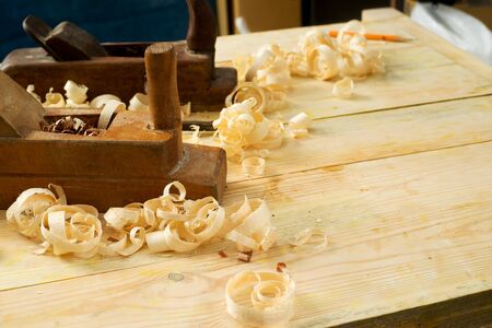 Carpenter tools on wood table background with sawdust. Copy space,