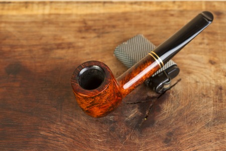 Smoking pipe on a wooden table. Aroma. Copy space. Top view.