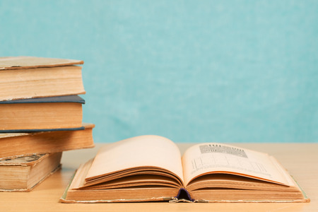 Open book, stack of hardback books on wooden table. Back to school. Copy space.の写真素材