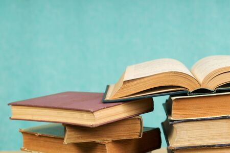 Open book, stack of hardback books. Back to school. Copy space.