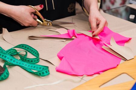 Sewing textile or cloth. Work table of a tailor. Textile tools. Scissors reel of thread, measuring tapes and natural fabric. Copy space.の写真素材