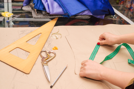 Sewing textile or cloth. Work table of a tailor. Textile tools. Scissors reel of thread, measuring tapes and natural fabric. Copy space.の写真素材