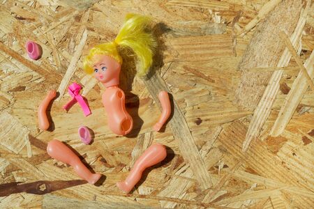 Doll body parts on a wooden background. Copy space. Top view.の写真素材