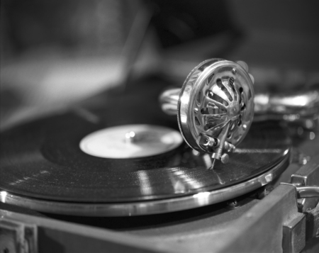Retro styled image of a collection of old vinyl record lps with sleeves. Browsing through vinyl records collection. Music background. Copy space. Old vintage gramophone in black and whiteの写真素材