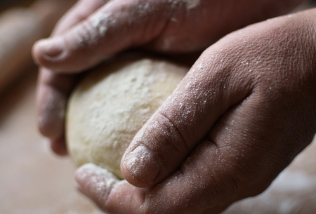 Old man holding a dough. Cook preparing raw dough for pizza. Handmade.の写真素材