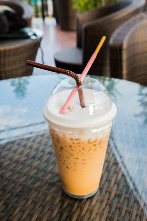 Iced coffee with straw and Pocky in plastic cupの写真素材