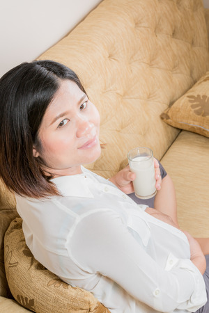 Pregnant woman holding and drinking a glass of milk.の写真素材