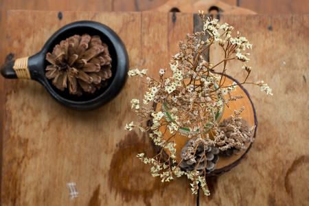 Bunch of dried  flowers in a glass vase on wooden table.の写真素材