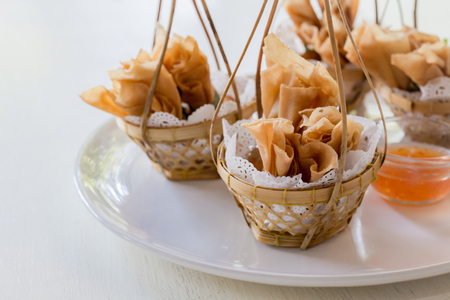Deep fried Chinese sheet wrap minced pork by shallot with sweet sauce call gold bag in Thai.Thai appetizersの写真素材
