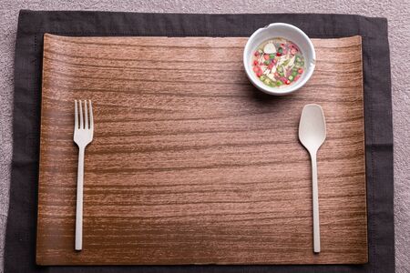 Wooden trey with spoon and fork on Placematの写真素材