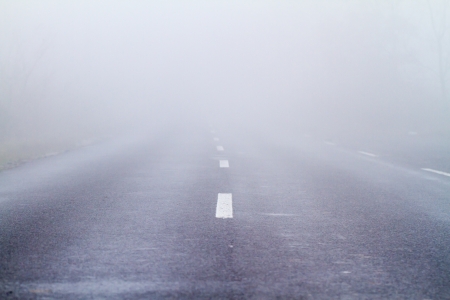 Asphalt road in an autumn fogの写真素材