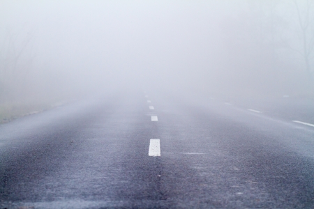 Asphalt road in an autumn fogの写真素材