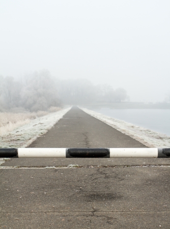 road to far away with barrier on freeze hoarfrosted landscapeの写真素材
