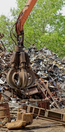 inustrial machine with scrap metal grapple in front of scrap ironの写真素材