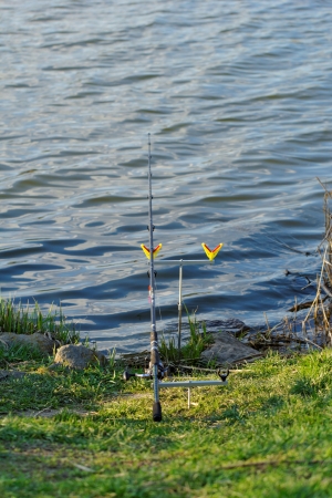 fishing rod on rack by the lakeの写真素材